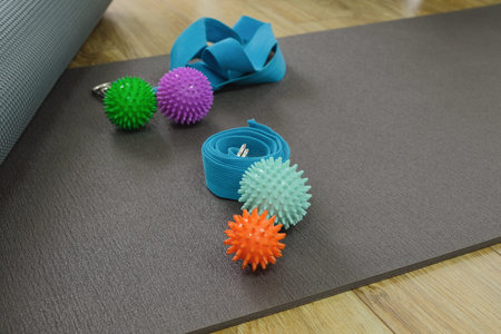 Yoga and stretching accessories in gym or sport studio, yoga mat, massage balls and yoga beltの写真素材