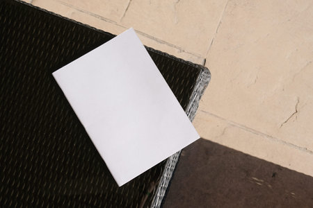 blank white magazine mockup on black wicker coffee table