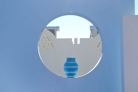 Blue antique vase in round hole in decorative wall outdoor, day sunlight. Exterior decor
