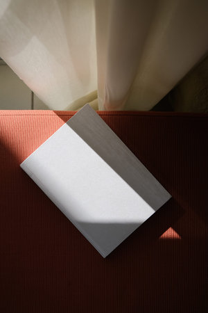 empty book mockup on soft blue chair, shadow overlay, hard light. For advertising, stationery...