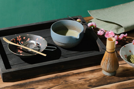 Green matcha powder and tea and whisk and spoon for preparation