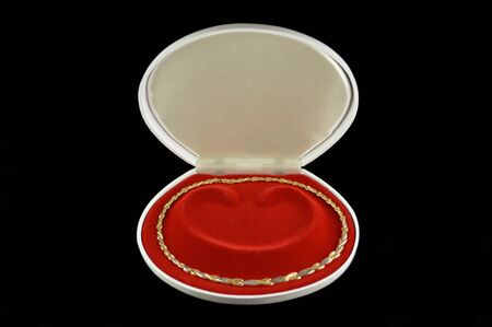 Gold necklace of white and yellow gold in a white box on a black background の写真素材
