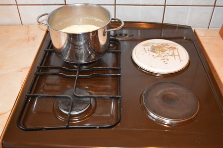 Milk in a saucepan on the stoveの写真素材