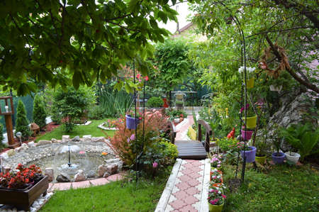 Serbian house garden, smooth green grass lawn, colorful flowering plant, in good care maintenance landscaped in the park stock photoの写真素材