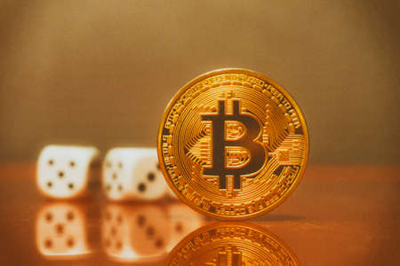 golden bitcoin with dice in the backgroundの写真素材