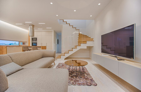 Interior of a modern house, living room with sofa and stairs