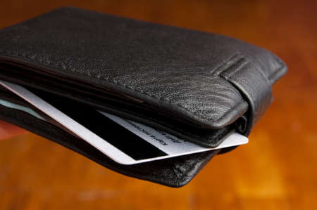 Black leather wallet on a Brown backgroundの写真素材