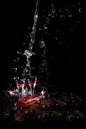 Broken glass with wine on a black backgroundの写真素材