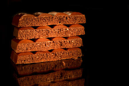 pieces of black aerated chocolate on black backgroundの写真素材