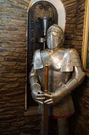 Ancient metal armor with iron detail near the wall of castleの写真素材