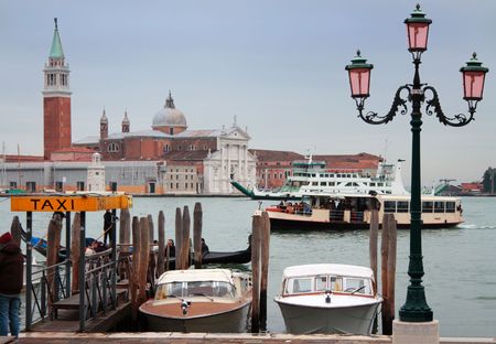 Taxi boats, gondola, vaporetto and ferry boat in front of San Giogio Maggiore Island, Venice, Italyの写真素材