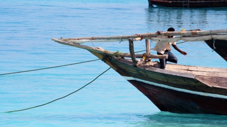 Zanzibar, Tanzania - October 18, 2010: A fisherman checks his boat before leaving for the deep in Nungwi, one of the most charming places in Zanzibarのeditorial素材