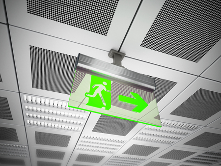 Exit sign hanging on suspended ceiling.の写真素材