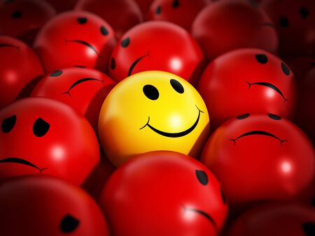 Yellow smiling face stands out against red spheres.の写真素材