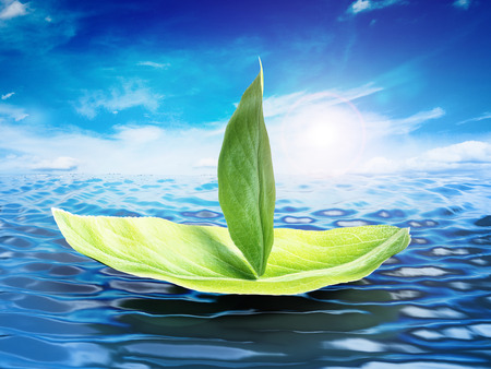 Green leaves forming a ship floating on sea level. 3D illustration.の写真素材