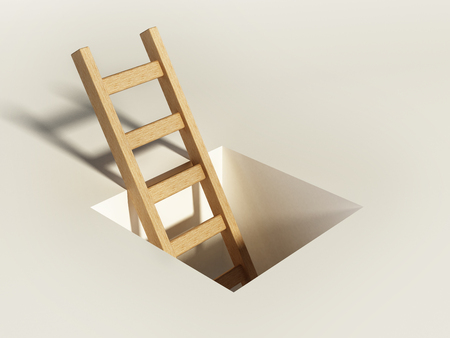 Wooden ladder rising above the square hole on the ground.の写真素材