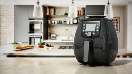 Air fryer with fried potatoes standing on kitchen counter. 3D illustration.の写真素材