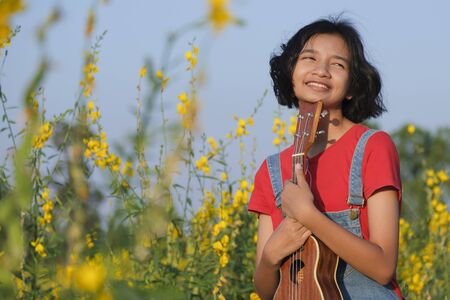 Happy Asian young girl at flower garden on summer with nice sky.の写真素材