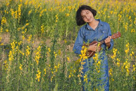 Happy Asian young girl at flower garden on summer with nice sky.の写真素材