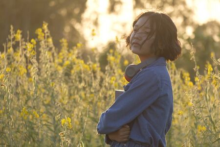 Happy Asian young girl at flower garden on summer with nice sky.の写真素材