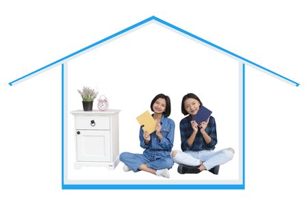 Two happy young asian girl enjoy time at home with white background.の写真素材