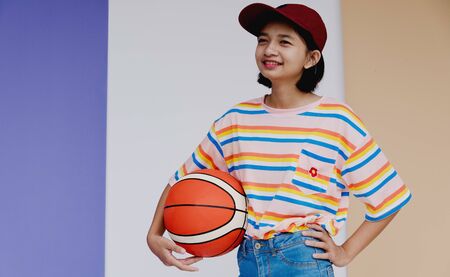 Happy young asian girl with basketball with pastel background.の写真素材