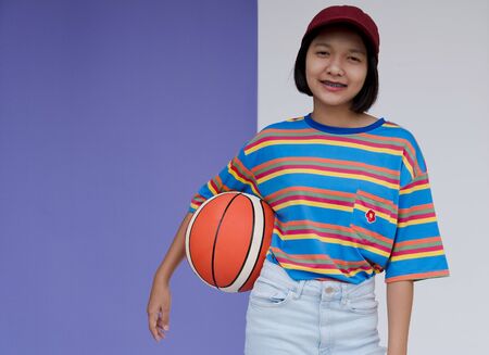 Happy young asian girl with basketball with pastel background.の写真素材
