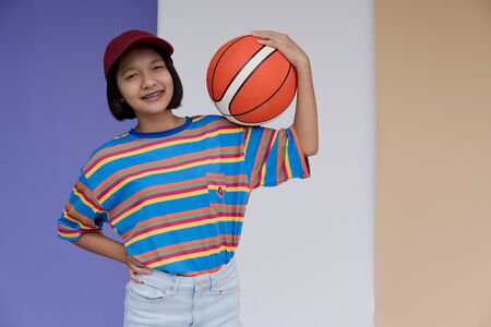 Happy young asian girl with basketball with pastel background.の写真素材