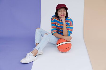 Happy young asian girl with basketball with pastel background.の写真素材