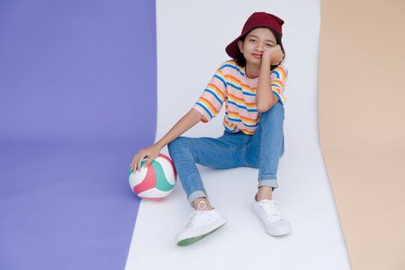 Happy young asian girl with volleyball and pastel background.の写真素材