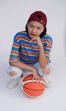Happy young asian girl with basketball with pastel background.の写真素材