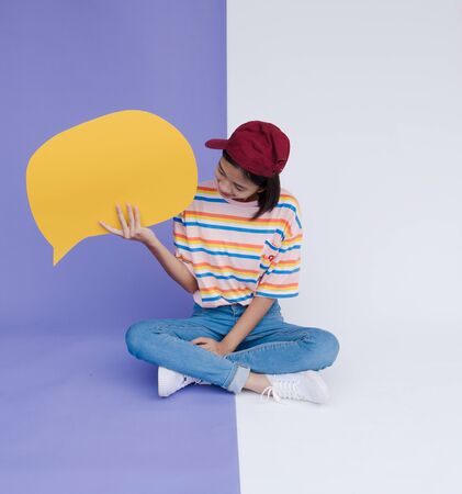 Happy asian young girl hold yellow bord with pastel background.の写真素材