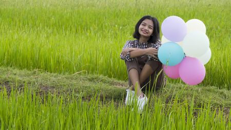 Asian young girl siting at beautiful field rice, Nature background.の写真素材