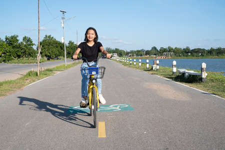 Asian young girl and  with bicycle at park.の写真素材