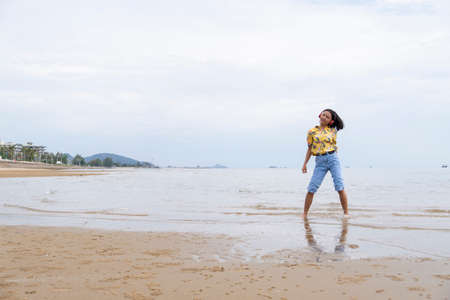 Young girl dancing and listening to music at a beautiful beach at Pranburi Prachuap Khiri Khan...