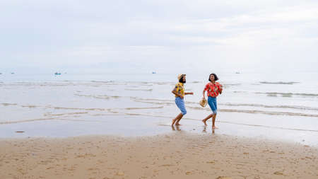 Two young girl walking at beautiful beach at Pranburi Prachuap Khiri Khan Thailand.の写真素材