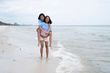 Two young girl having fun at beautiful beach.の写真素材