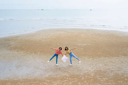 Two asian girl wear colorful shirt in happy emotion at beach.