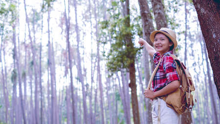 Young girl at pine forest wear hat and red shirt at Phu Pha Man Khonkaen Thailand.の写真素材