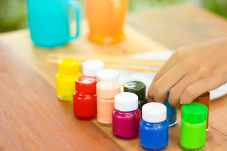 Hand touch color bottle on table.の写真素材