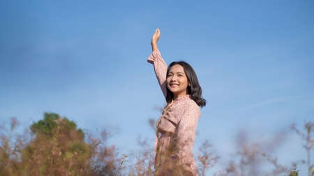 Happy young girl wear dress standing at the field grass.の写真素材