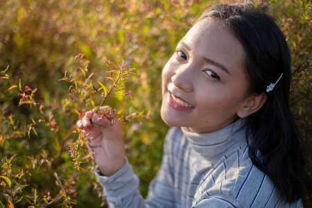 Portrait face of beautiful young girl at field grass in sunset time.