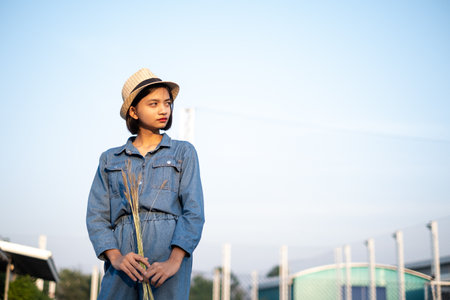 Young Asian girl hold grass flowers. Health park background.の写真素材