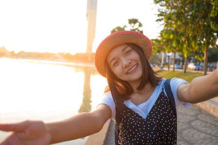 Beautiful young girl taking picture of herself or selfie with landscape view at Roi-et Thailand