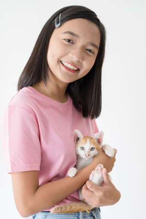 Happy young girl with cat and white background.の写真素材