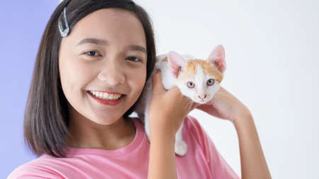Happy young girl with cat and white background.の写真素材