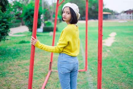 Happy young girl wear yellow sweater and jeans at playground.の写真素材
