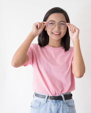 Happy young girl wearing glasses on white background.の写真素材