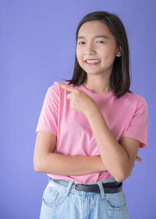 Happy young girl wear pink T-Shirt and jean on blue background.の写真素材