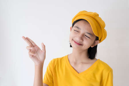 Young Asian girl wear yellow hat and T-Shirt on white background.の写真素材